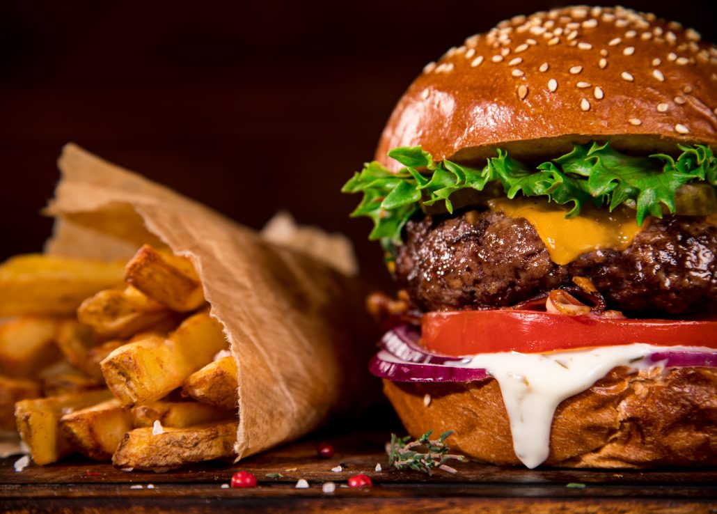 Tasty burger on wooden table.